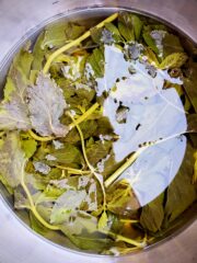 A saucepan with fresh mint tea concentrate that is cooling.