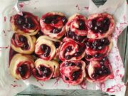 12 messy Blueberry Cinnamon Rolls that have been placed in a 9×13 inch pan.