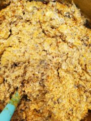 Pan of sausage cream cheese mixture with a blue spatula in it.